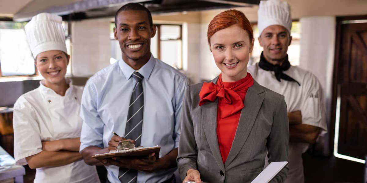 Hospitality management team and chefs in a commercial kitchen
